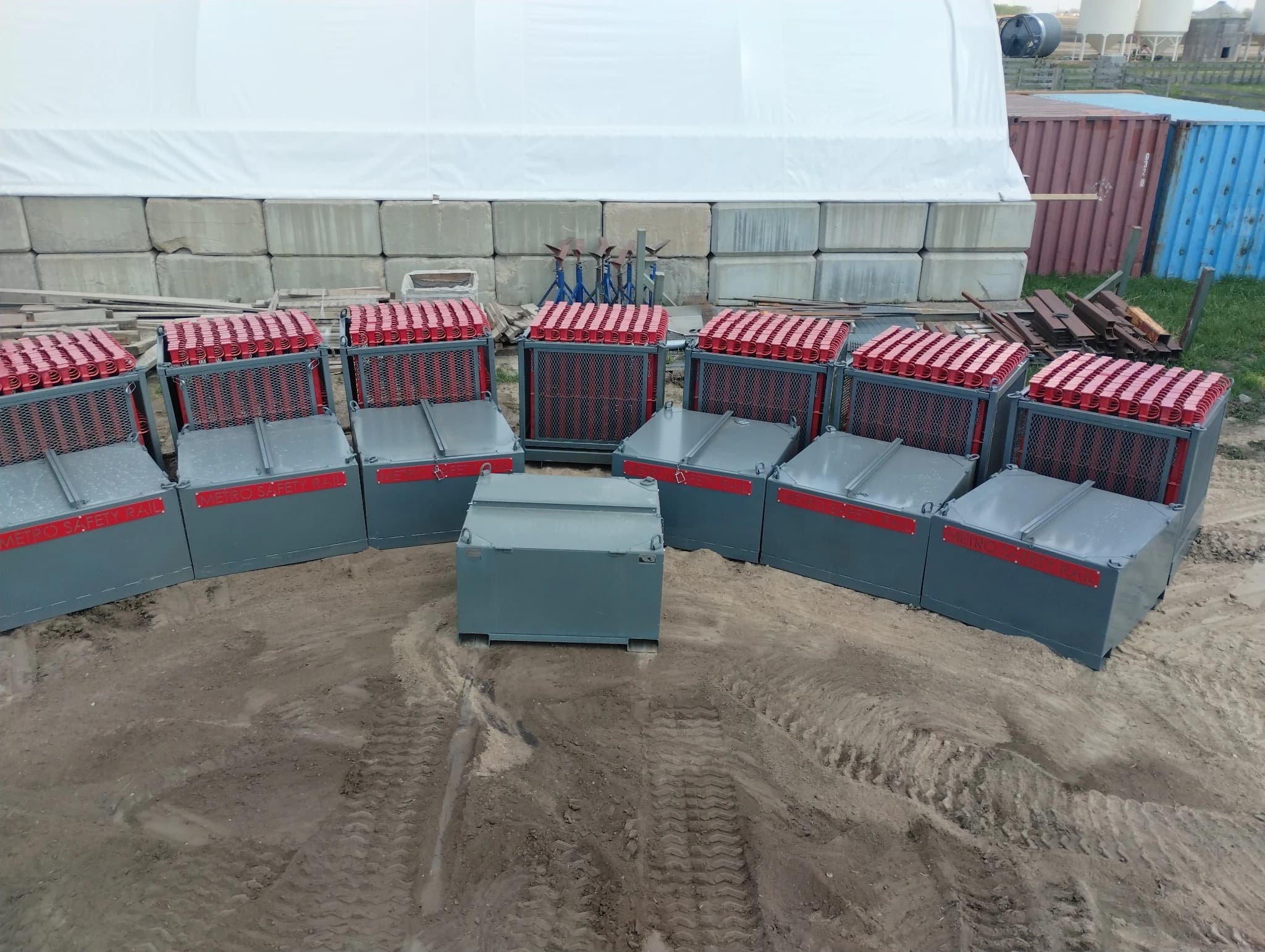 Metro Safety Rail staging containers arranged on site, loaded with guardrail components ready for hoisting.